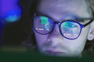 Close up of a man looking at a computer screen.