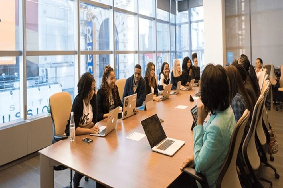 Team of staff sit around a conference table.