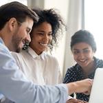 three people working together on a laptop computer