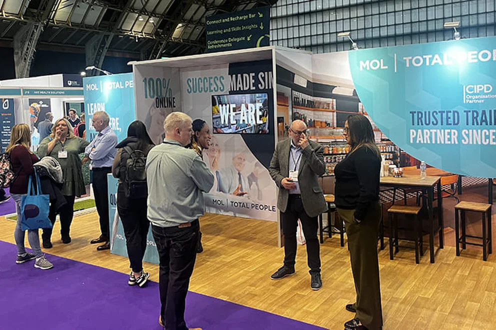 An image of the MOL team chatting to attendees at the 2023 CIPD ACE event.