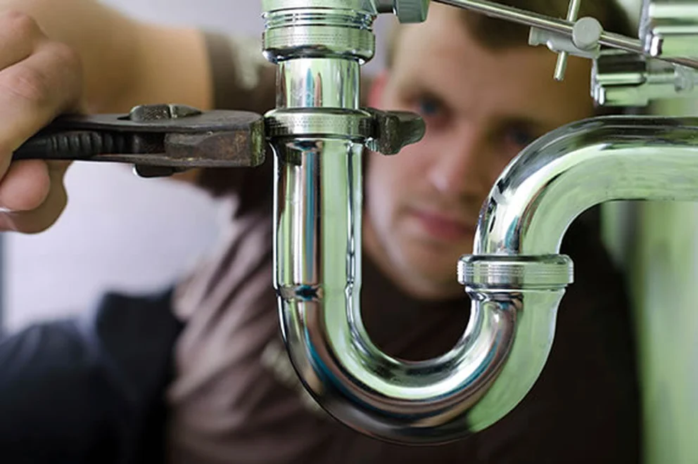 Close up of plumber working on some metal pipes