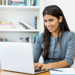 Young woman working on a laptop computer smiling
