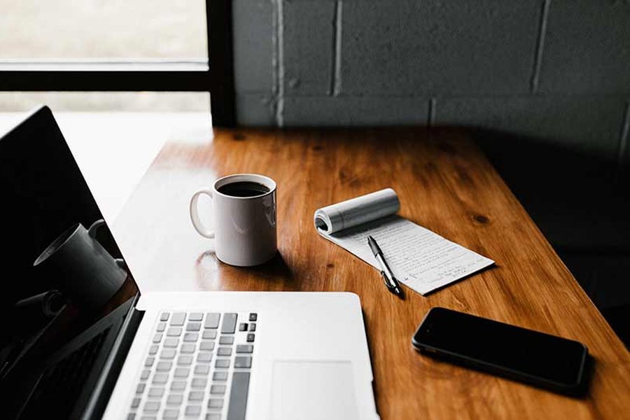 A desk with a laptop and phone on it