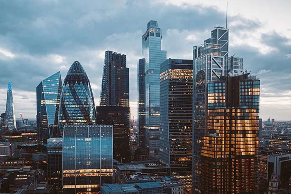 An image of the skyline in Canary Wharf at sunrise on an overcast day.