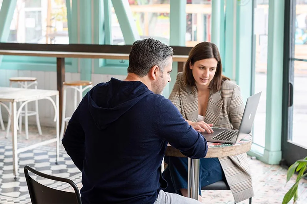 Two people sat talking at a desk