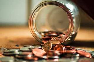 Money tipping out of a jar.