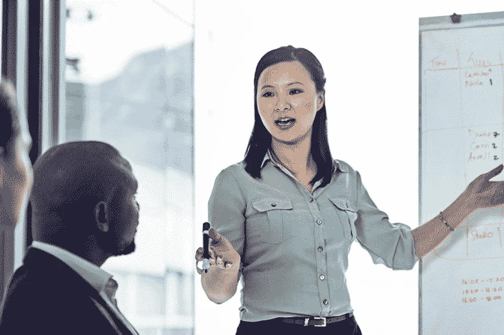 Woman standing in front of a whiteboard and giving a presentation