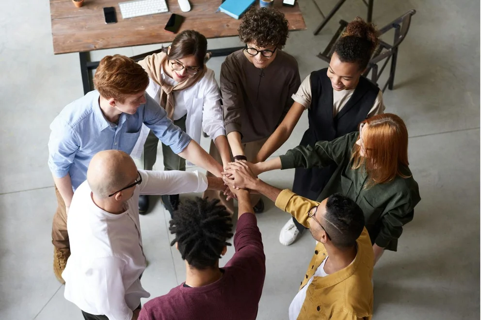 A group of colleagues putting their hands together