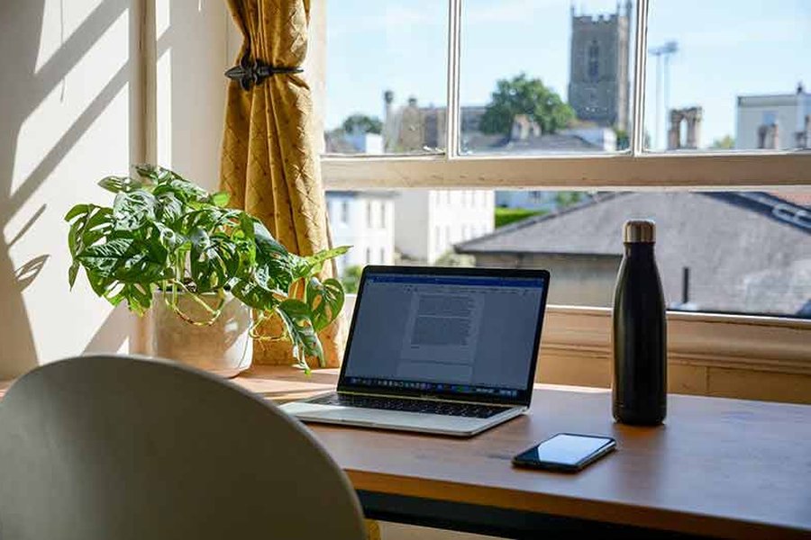 Laptop and phone on a desk withn a scenic view