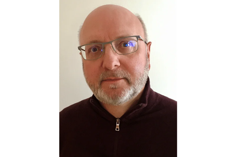 John King wearing glasses and a black sweater