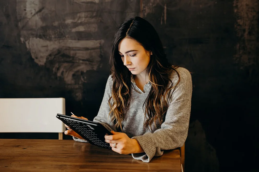 Woman with long dark hair working on a tablet