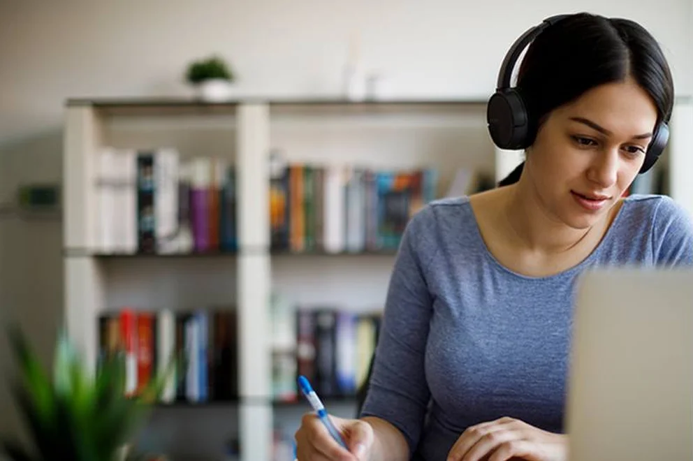 A woman sat with headphones doing work.