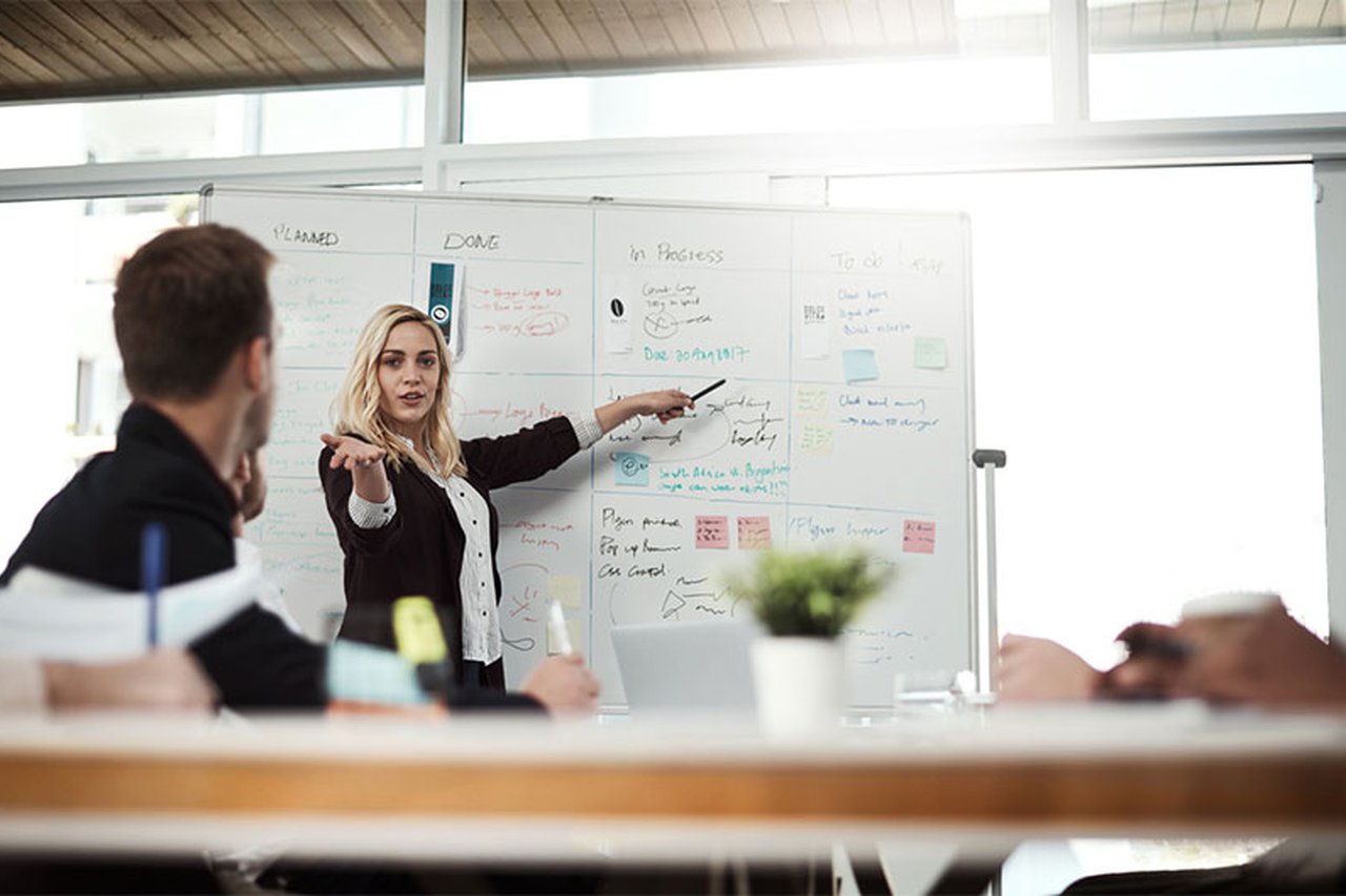 An employee leading a discussion with notes on a whiteboard