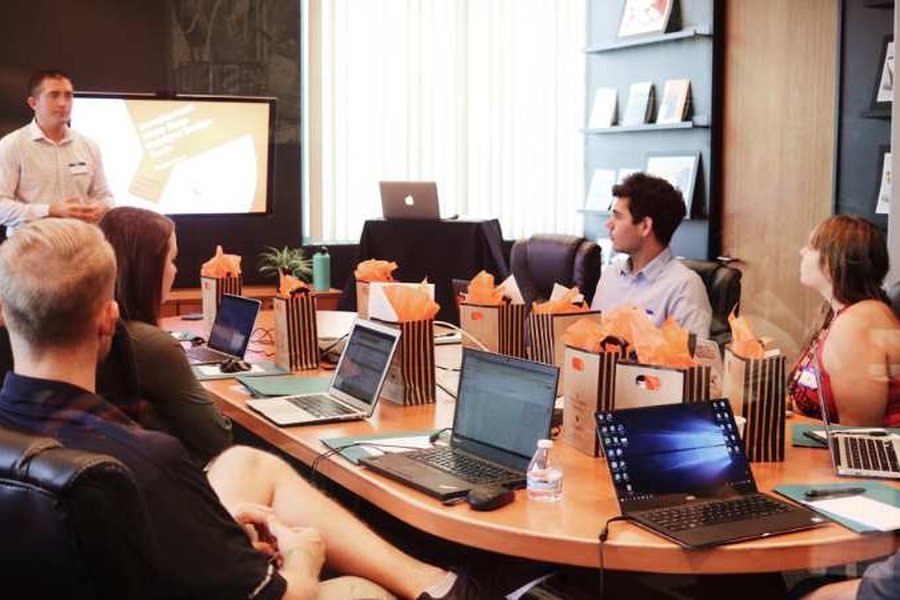 People sat around a meeting room table watching someone present