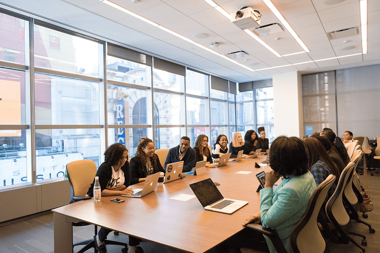 Team of staff sit around a conference table.