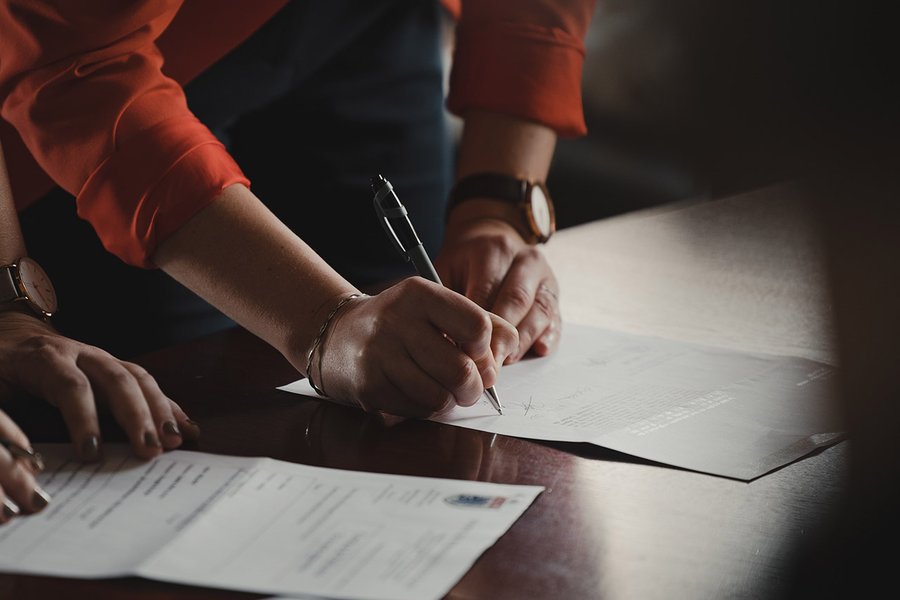 Person signing a piece of paper.