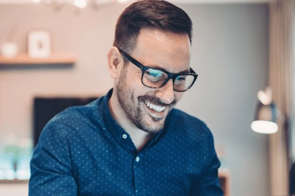 An image of a man using a laptop in a home-office setting.