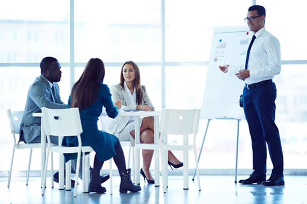 People sitting at a table and watching a business presentation