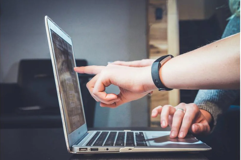 A man pointing at a laptp screen