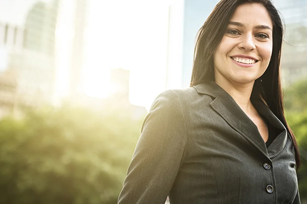 Woman with long dark hair smiling and wearing a business suit