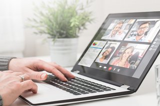 The image shows a laptop with a number of people attending an online class.