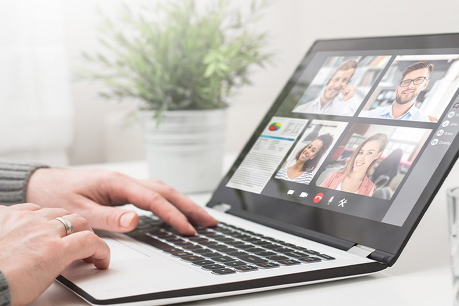 The image shows a laptop with a number of people attending an online class.