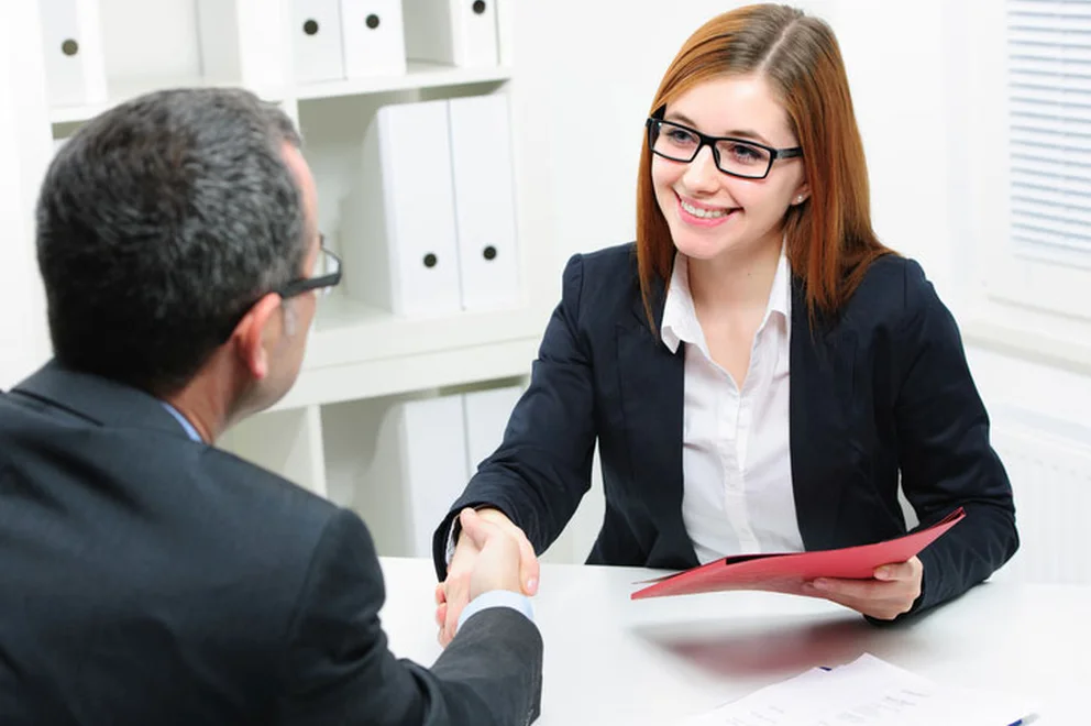 Two people shaking hands at a table