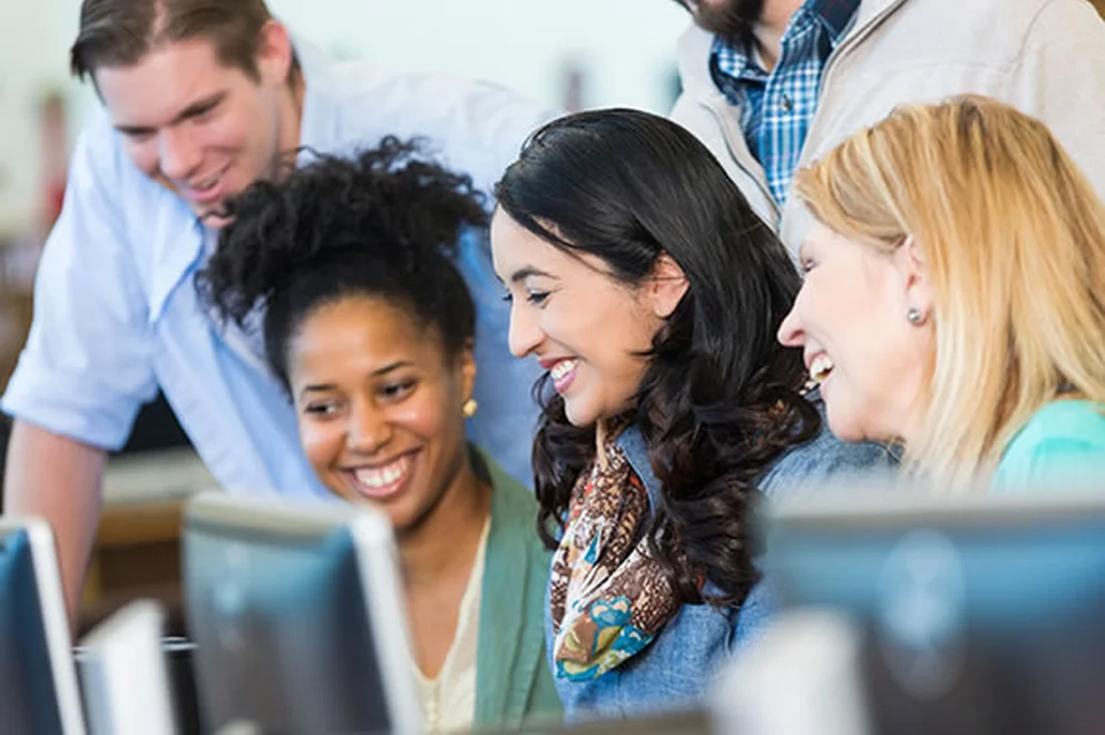 People looking at a computer screen and smiling