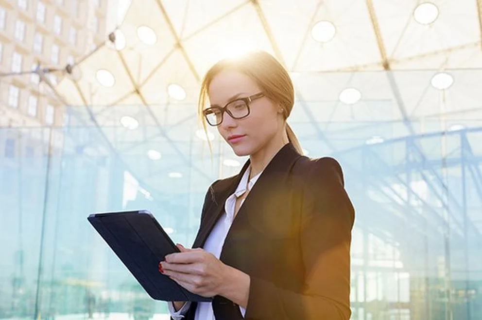 Woman wearing a business suit looking at a tablet