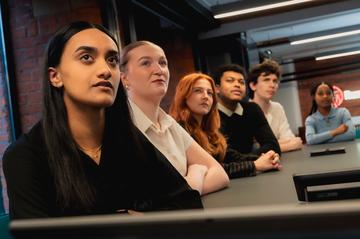 Six HR apprentices watching a presentation together.