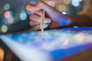 We see a hand drawing on an iPad-style tablet with a stylus.