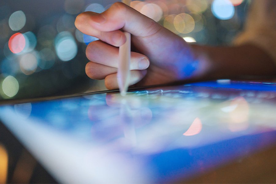 We see a hand drawing on an iPad-style tablet with a stylus.