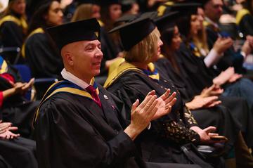 Khaled Shaker, CIPD L7 Graduate, applauding other graduates.