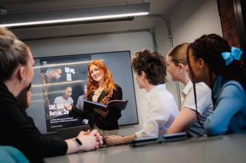 A colleague presenting a powerpoint to other colleagues