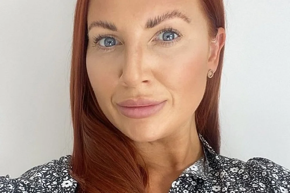Close up portrait of a woman with red hair and a floral blue and white blouse