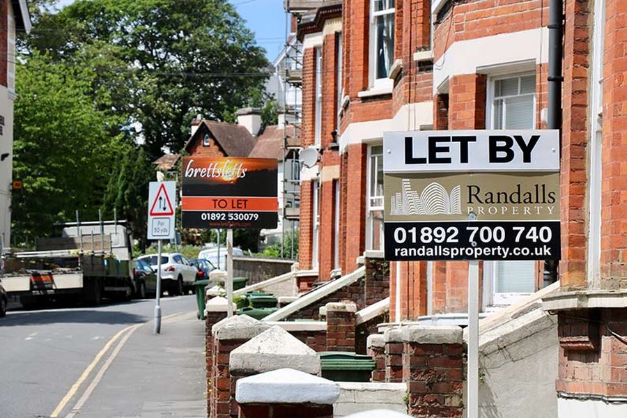 A row of houses with property agent signs