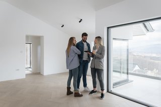 Female estate Agent shows an apartment to a man and woman.