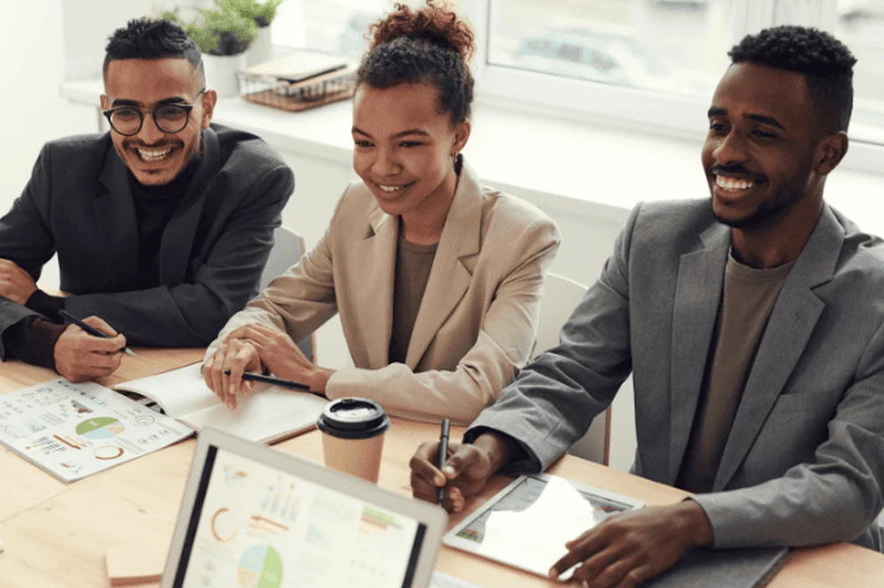 A group of three having a meeting smiling