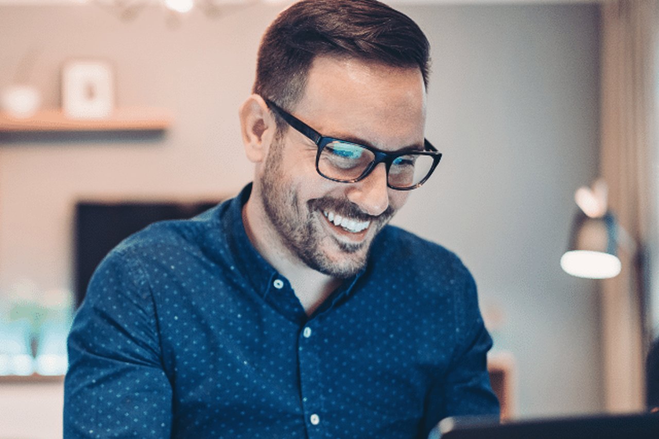An image of a man using a laptop in a home-office setting.
