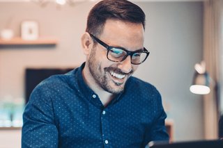 An image of a man using a laptop in a home-office setting.
