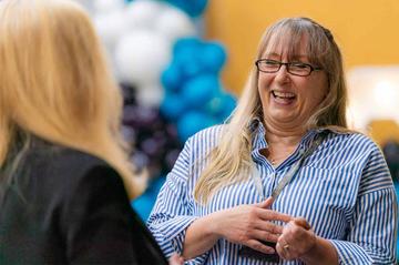 A female MOL employee is laughing at an event to celebrate the company's 40th anniversary.