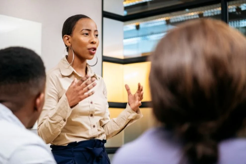 A woman presenting infront her colleagues