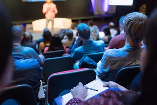 An audience watching a speaker on-stage