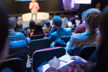An audience watching a speaker on-stage