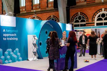 A group of people are standing around MOL's stand at CIPD ACE 2024.