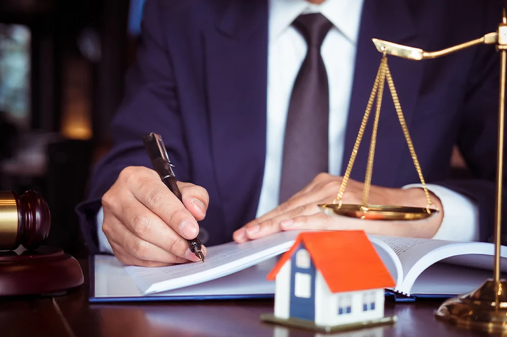 We can see an anonymous conveyancer writing notes at their desk.
